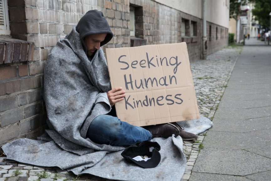Male,Beggar,In,Hood,Showing,Seeking,Human,Kindness,Sign,On